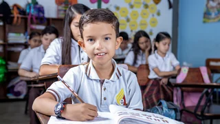 Miniatura de estudiante escribiendo